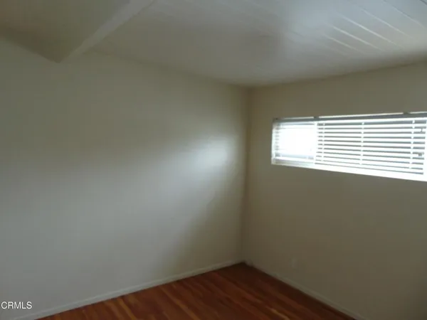 a view of small space with wooden floor and a window