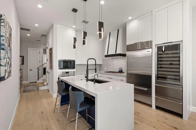 a kitchen with stainless steel appliances kitchen island a refrigerator sink and cabinets