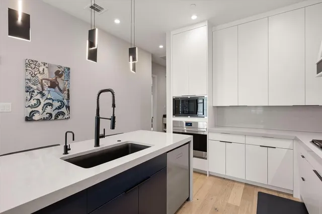 a kitchen with a sink a stove and cabinets
