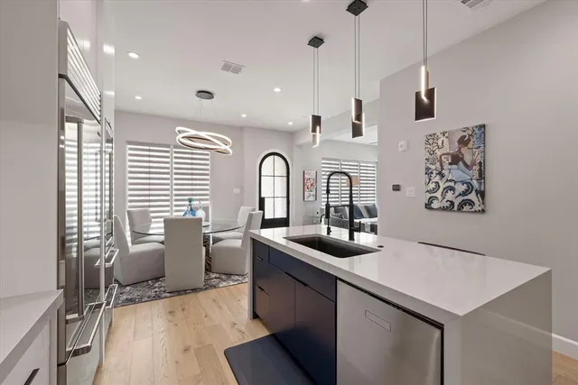 a kitchen with stainless steel appliances granite countertop a sink stove and wooden floor