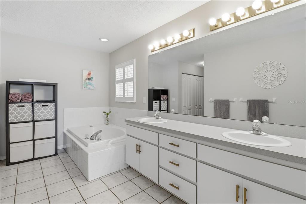 3189 South Graymor Path Inverness, FL 34450 - Photo 32 of 46 a spacious bathroom with a double vanity sink a mirror and a bathtub