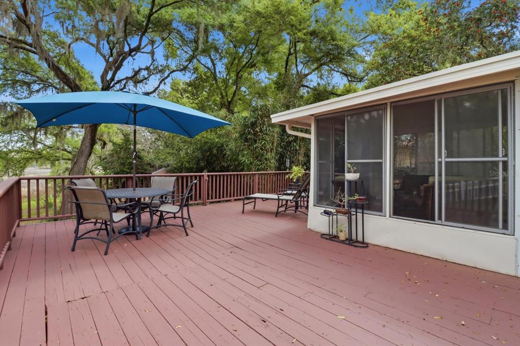 3189 South Graymor Path Inverness, FL 34450 - Photo 39 of 46 a view of a roof deck with table and chairs under an umbrella with wooden floor