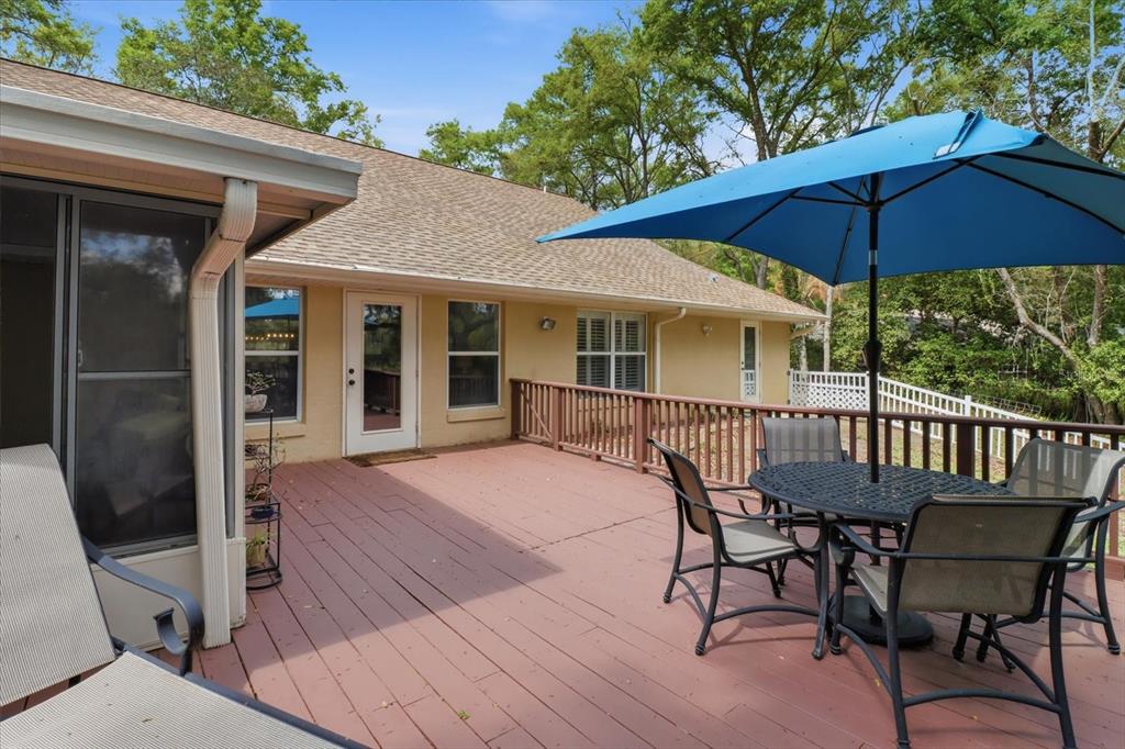 3189 South Graymor Path Inverness, FL 34450 - Photo 40 of 46 a patio with wooden floor a yard a table and chairs