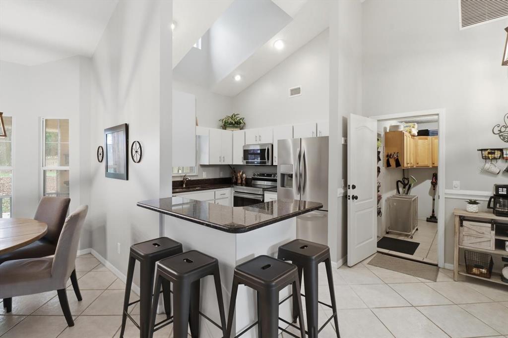3189 South Graymor Path Inverness, FL 34450 - Photo 10 of 46 a kitchen with stainless steel appliances a refrigerator a stove a dining table and chairs