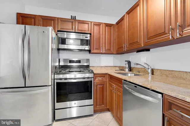 a kitchen with stainless steel appliances granite countertop a refrigerator stove and sink
