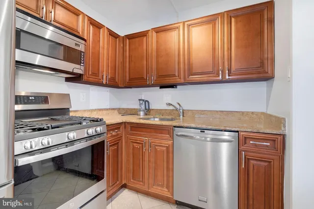a kitchen with stainless steel appliances granite countertop a stove a sink and a microwave
