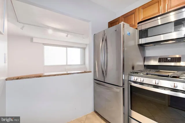 a kitchen with stainless steel appliances a refrigerator a stove and a window