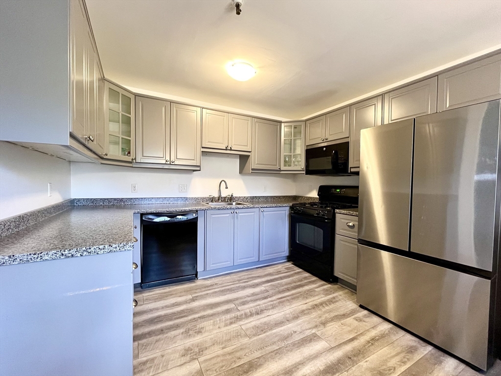 74 Tennis Plaza Road, Unit 34 Dracut, MA 01826 - Photo 3 of 25 a kitchen with a refrigerator sink and microwave