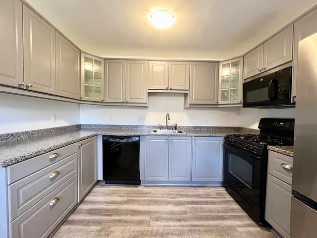 a kitchen with granite countertop cabinets stainless steel appliances and a window