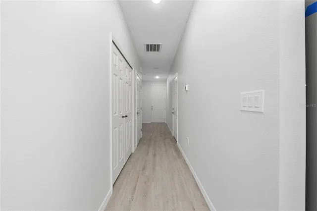 a view of a hallway with wooden floor