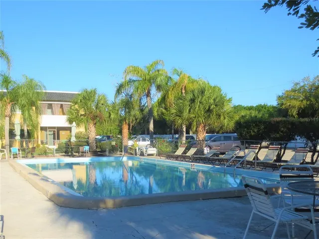 a view of a house with pool and chairs