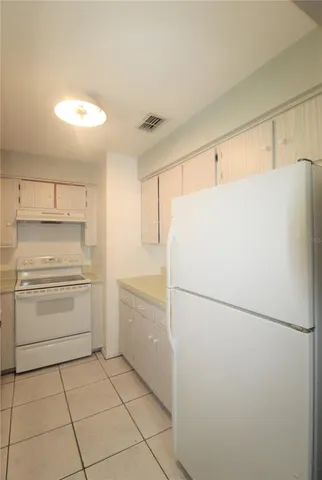 a white refrigerator freezer and a stove sitting inside of a kitchen