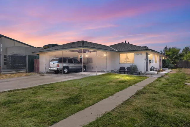a front view of a house with a garden and yard