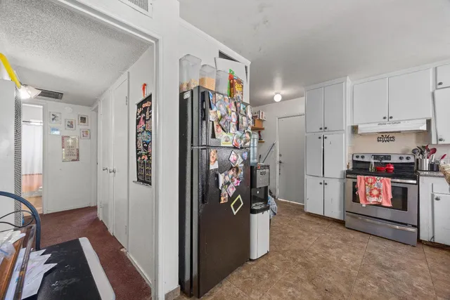 a kitchen with stainless steel appliances granite countertop a refrigerator and cabinets