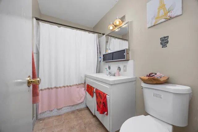 a bathroom with a sink a toilet and shower curtain