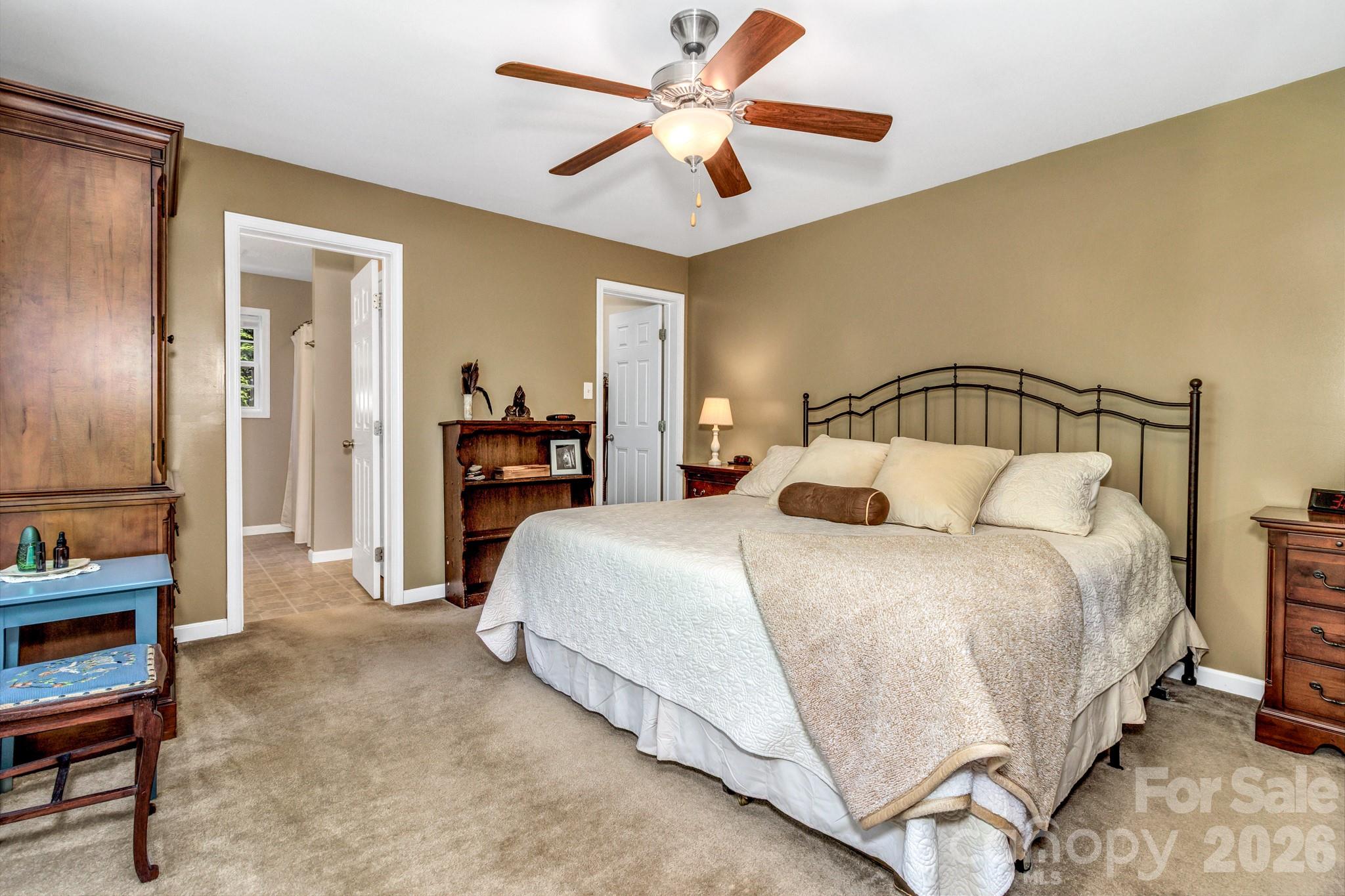152 Joe Jenkins Road Fairview, NC 28730 - Photo 18 of 44 a bedroom with a bed and a chandelier