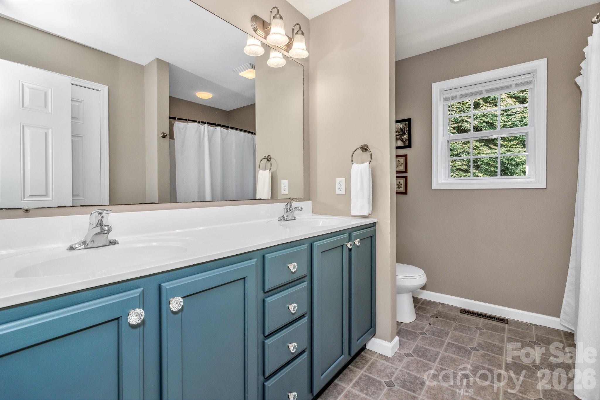 152 Joe Jenkins Road Fairview, NC 28730 - Photo 20 of 44 a bathroom with a granite countertop sink a toilet and a mirror