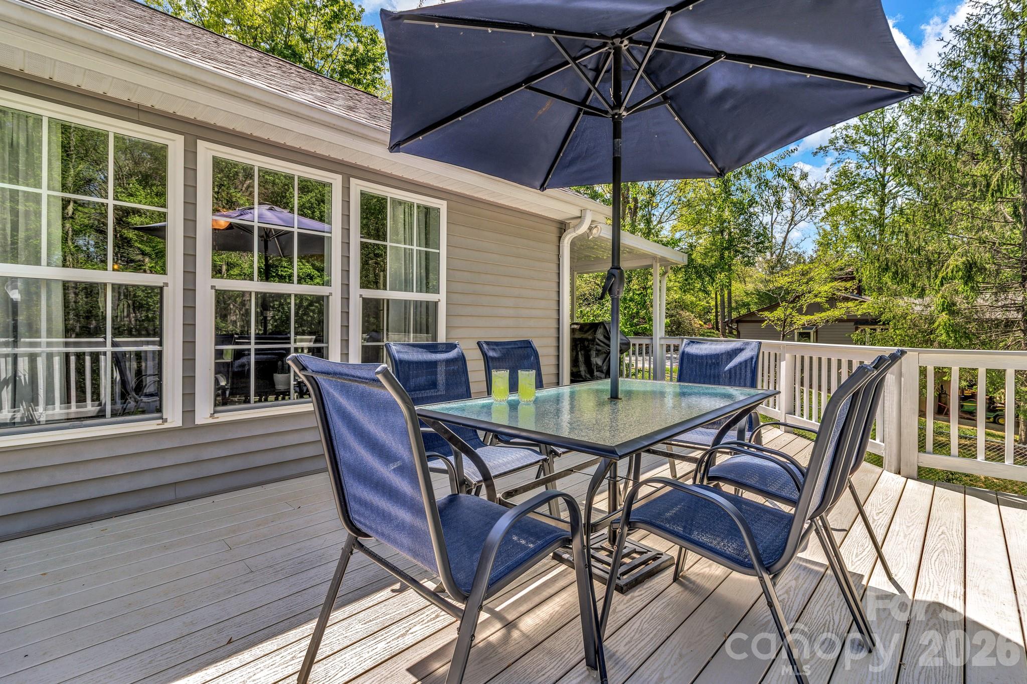 152 Joe Jenkins Road Fairview, NC 28730 - Photo 33 of 44 a patio with wooden floor a yard a table and chairs