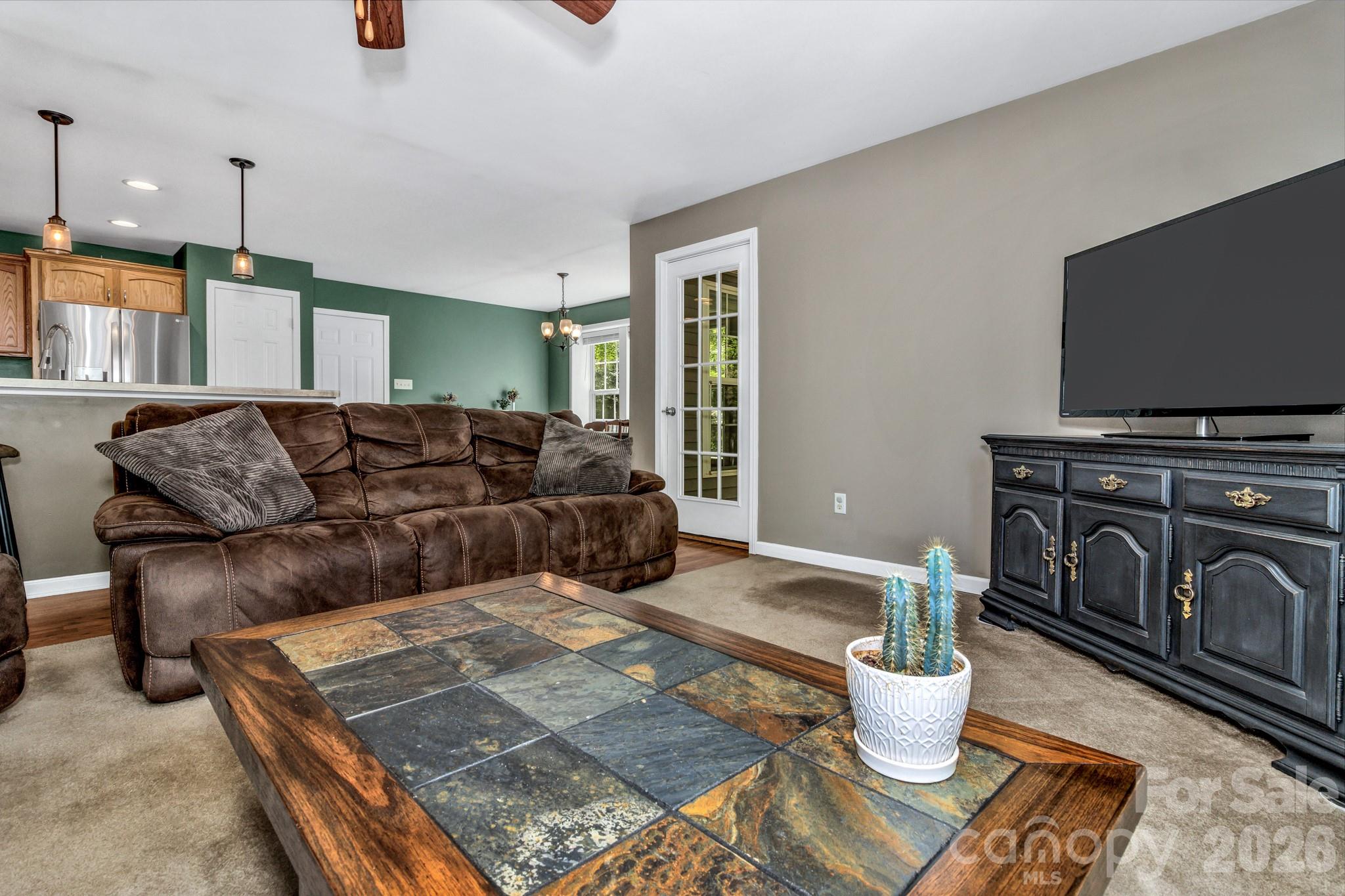 152 Joe Jenkins Road Fairview, NC 28730 - Photo 10 of 44 a living room with furniture a flat screen tv and kitchen view
