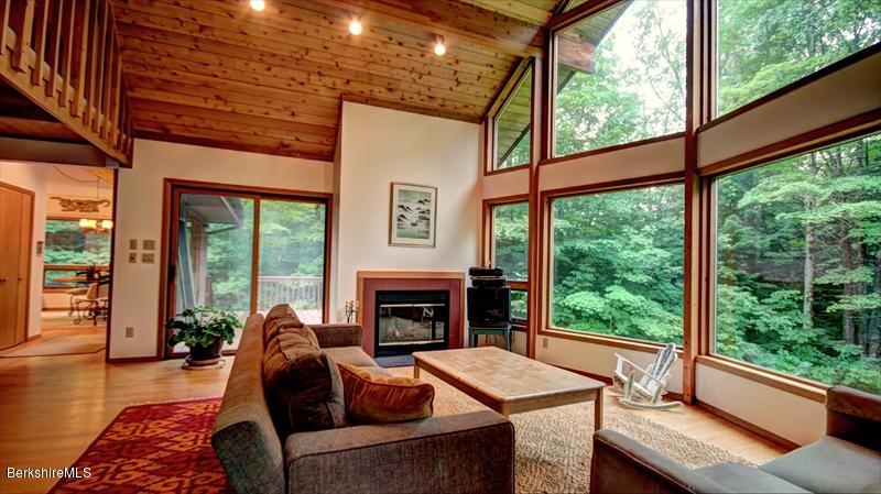 517 Dimmock Road Otis, MA 01253 - Photo 5 of 21 a living room with furniture a fireplace and floor to ceiling windows