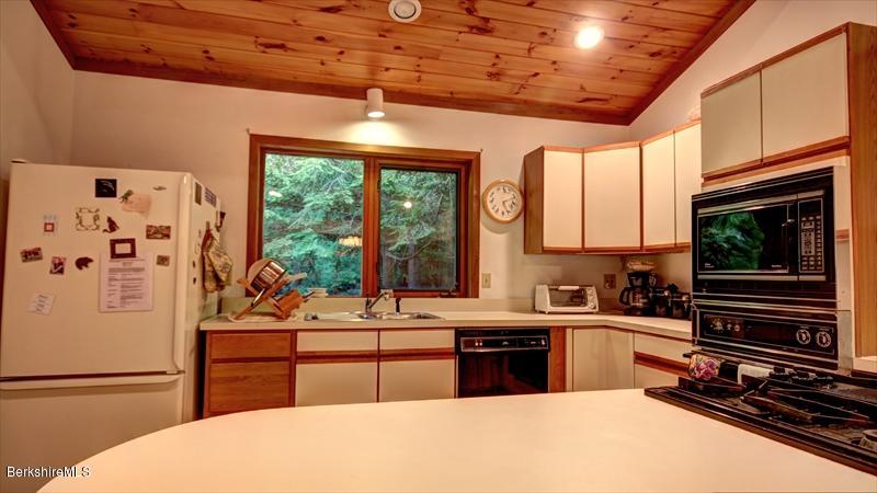 517 Dimmock Road Otis, MA 01253 - Photo 10 of 21 a kitchen with stainless steel appliances kitchen island granite countertop a refrigerator and a stove top oven