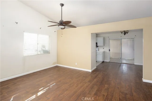 a view of a room with wooden floor and a ceiling fan