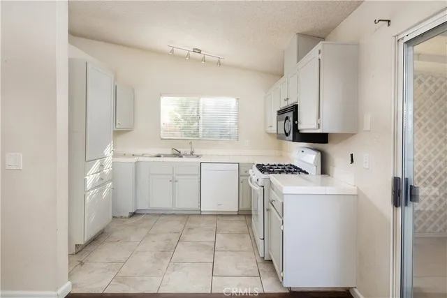a view of a kitchen with a sink and a stove top oven