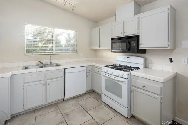 a view of a kitchen with white cabinets