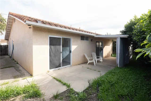 a backyard of a house with table and chairs