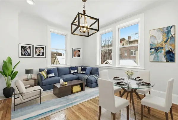 a living room with furniture a chandelier and a wooden floor