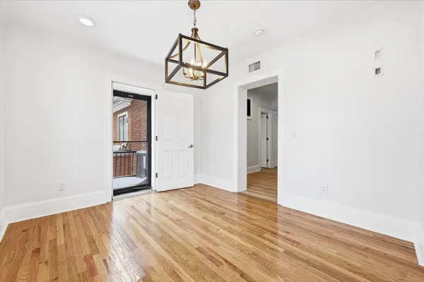 a view of a room with wooden floor and ceiling fan