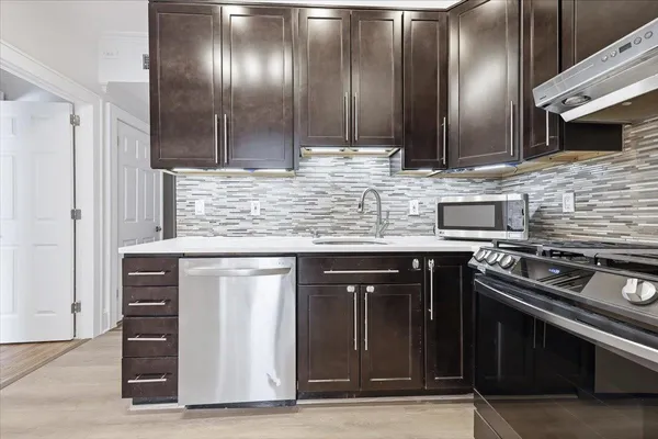 a kitchen with stainless steel appliances granite countertop a sink stove and cabinets