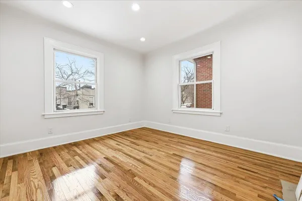 a view of a big room with wooden floor and windows