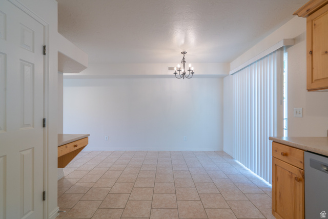 1735 West 540 North, Unit 1805 St. George, UT 84770 - Photo 20 of 64 Spacious dining area featuring neutral-toned tile flooring, a multi-arm chandelier, and vertical blinds on a sliding glass door