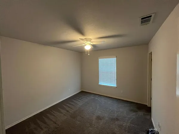 an empty room with a window and a fan