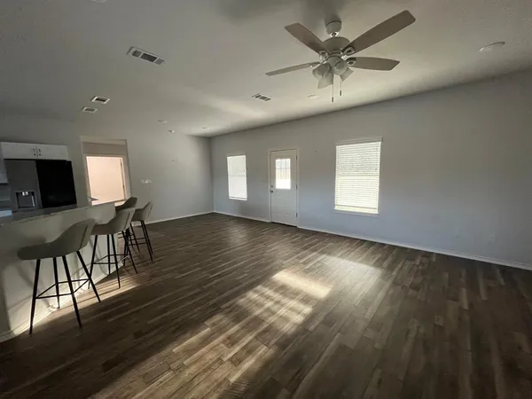 a view of a livingroom with furniture a ceiling fan and wooden floor