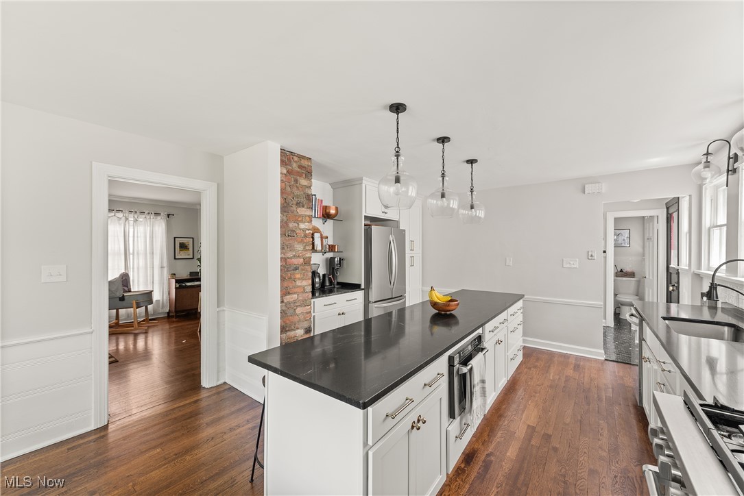 2464 Channing Road Cleveland, OH 44118 - Photo 13 of 44 Kitchen with stainless steel appliances, dark countertops, dark wood finished floors, white cabinets, and a center island