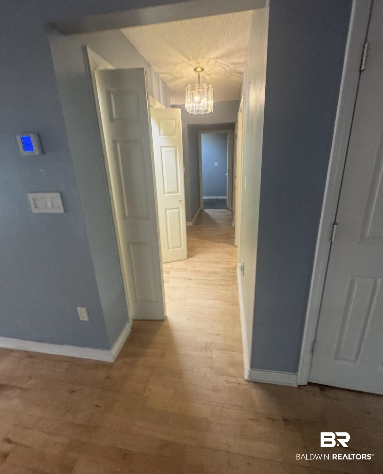 23341 County Road 49 Silverhill, AL 36576 - Photo 22 of 23 Hallway featuring a chandelier and light wood finished floors