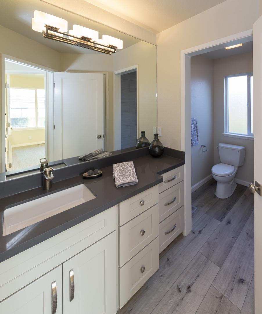 134 Hughes Road Watsonville, CA 95076 - Photo 11 of 26 a bathroom with a granite countertop sink a toilet and a mirror