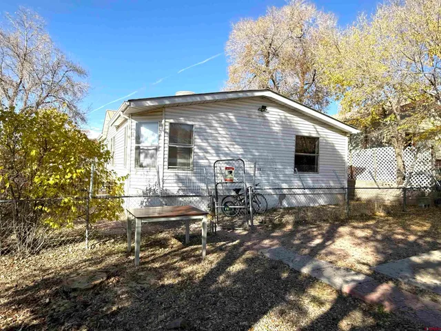 a backyard of a house with table and chairs