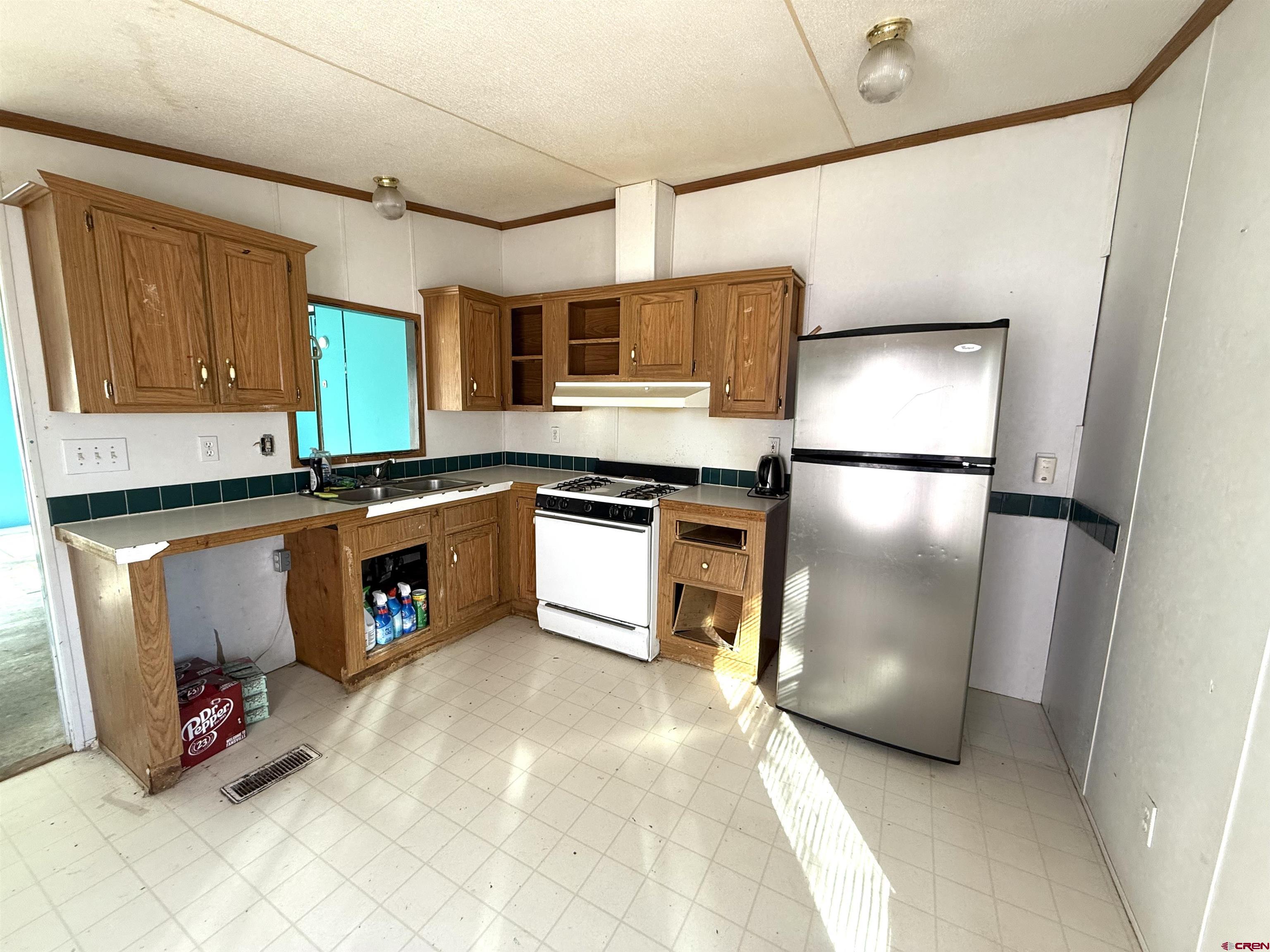 519 South Beech Street Cortez, CO 81321 - Photo 9 of 12 a kitchen with stainless steel appliances granite countertop a sink a stove a refrigerator and cabinets