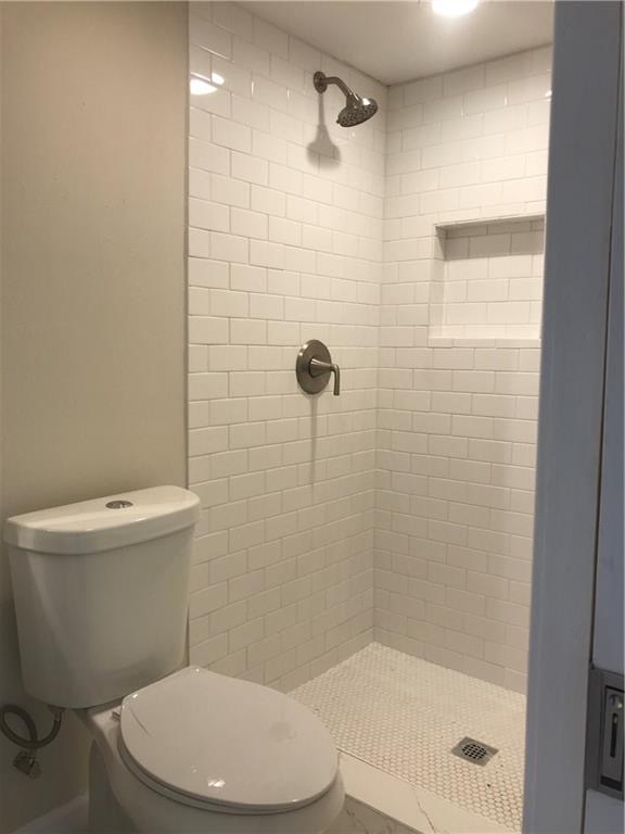1119 Spur Street, Unit A Austin, TX 78721 - Photo 6 of 10 A well-appointed shower space featuring white subway tile and a practical niche.