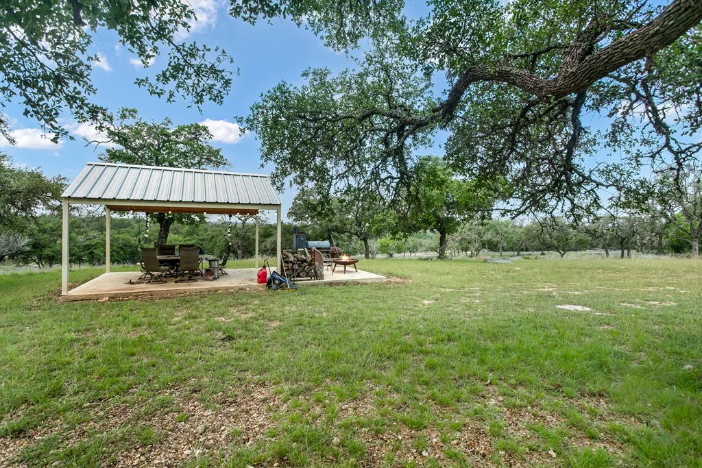 181 Real Lake House Road South Kerrville, TX 78028 - Photo 1 of 18 a view of a house with a backyard and a patio