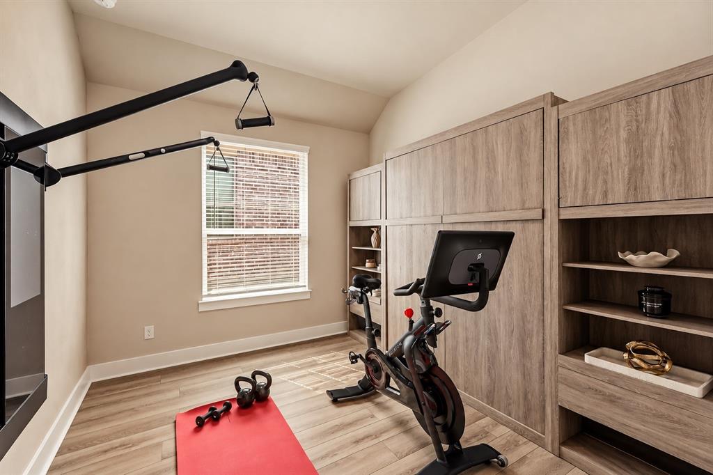 5112 Holy Springs Road Denton, TX 76207 - Photo 18 of 24 Secondary Bedroom 3 shown with the wall bed tucked away, transforming the space into a spacious and functional home gym while showcasing the room’s versatility.