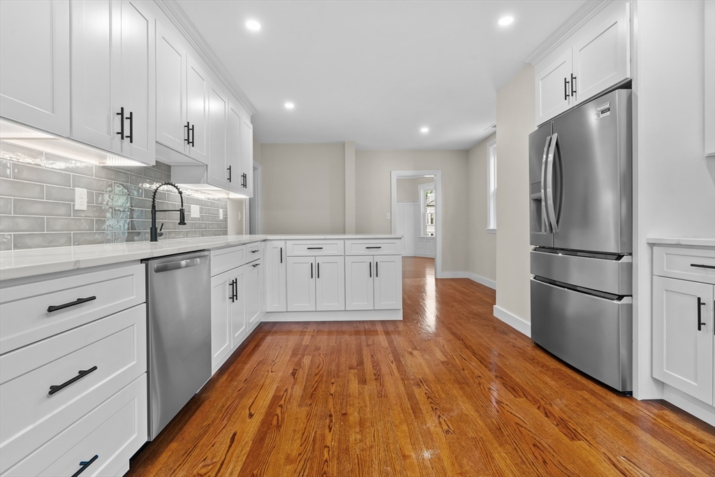 35 George Street, Unit 35 Newton, MA 02458 - Photo 16 of 36 a large kitchen with a center island wooden floor stainless steel appliances and cabinets