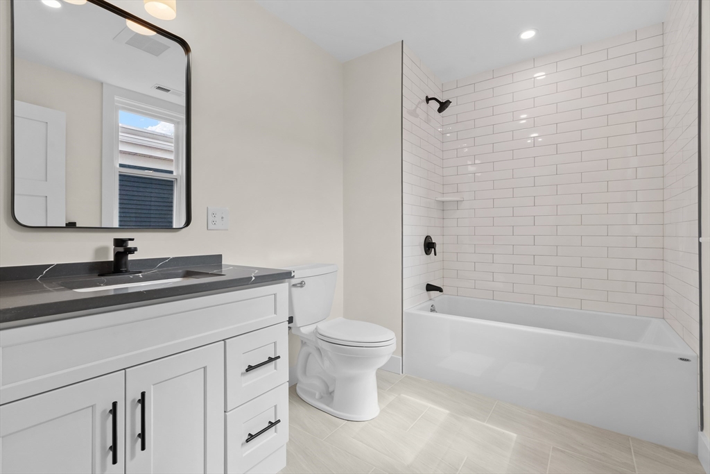 35 George Street, Unit 35 Newton, MA 02458 - Photo 25 of 36 a bathroom with a granite countertop sink a toilet and shower