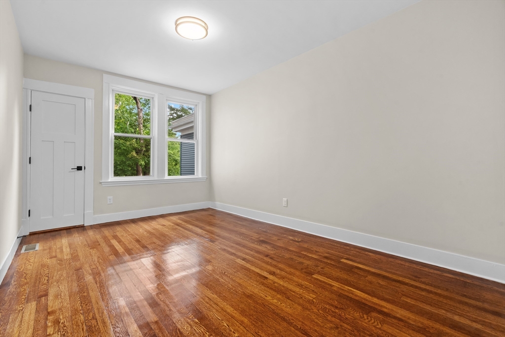 35 George Street, Unit 35 Newton, MA 02458 - Photo 5 of 36 a view of an empty room with wooden floor and a window