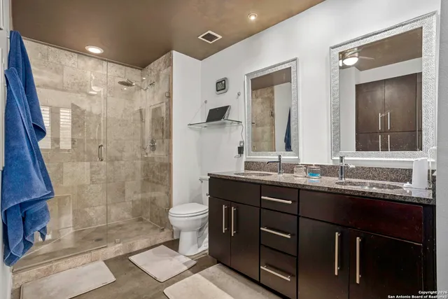 a bathroom with a double vanity sink toilet and shower