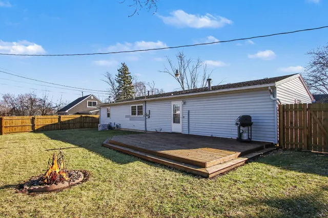 a view of a backyard with table and chairs and a fire pit