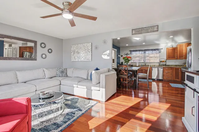 a living room with furniture and a view of kitchen